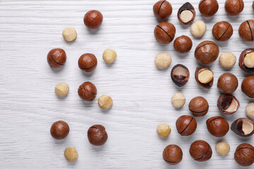 Delicious Macadamia nuts on white wooden table, flat lay