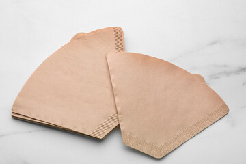Paper coffee filters on white marble table, above view