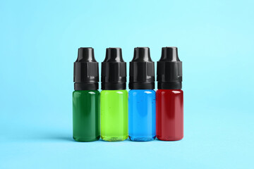 Bottles with different food coloring on light blue background