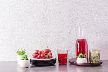 kitchen background with a copy of the space. still life. a jug of grape juice, a plate of grapes on the kitchen countertop.