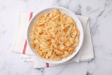 Bowl with tasty sauerkraut on white marble table, top view