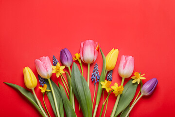 Beautiful different flowers on red background, flat lay
