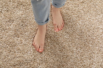 Woman standing on soft carpet at home, closeup