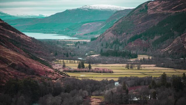 Timelapse of a U-shaped valley containing fields, livestock, farmland, rivers and a road. Shot near Ullapool, part of the West Highlands of Scotland.
