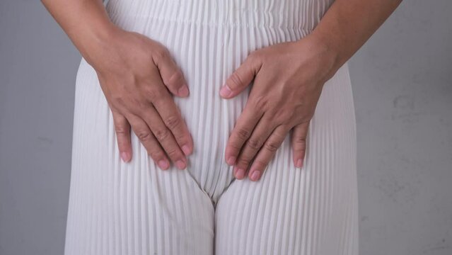 Woman holding heart shape hands on her crotch isolated on white background. Gynecological and Health hygiene concept.