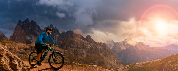 Fototapeta na wymiar A man ride electric mountain bikes in the Dolomites in Italy. Mountain biking adventure on beautiful mountain trails.