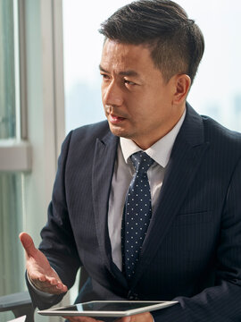 asian businessman speaking during meeting in office