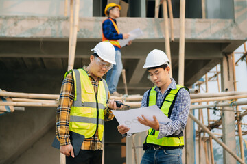 Architect caucasian man working with colleagues mixed race in the construction site. Architecture engineering on big project. Building in construction interior.