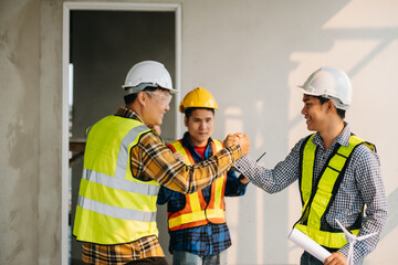 Engineer desk with object paper and tablet with blurry engineer teamwork hardworking to consults about their building project..
