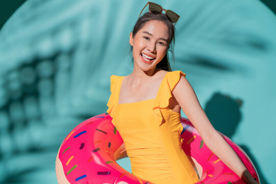 hello summer greeting young asia female woman in swimwear playful joy fun playing face expression hand gesture hold donut shape inflatable, woman ready to have fun in summer time relax casual vacation