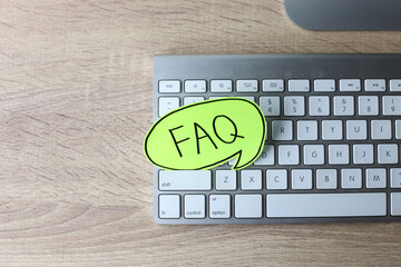 Question mark on sticky notes and FAQ writing on sticky note at office desk. FAQ concept. Working...
