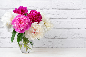 Bouquet of pink and white peony flowers in vase on white brick wall background. Mockup, template for holiday, birthday, mother's day. Banner, header with copy space