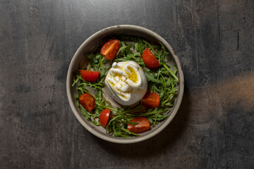 Burrata, mozzarella and cream, salad with arugula and tomato