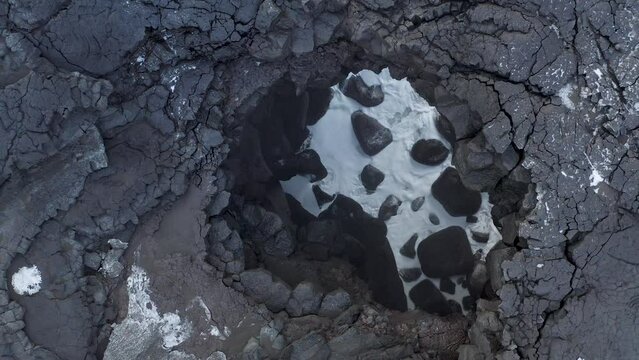 Topdown View Of Coastal Volcanic Rocky Holes With Crashing Foamy Waves In Iceland. Aerial Shot