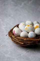 Small Easter eggs lie in a nest on a white background