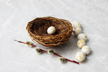 Small Easter eggs and willow on the table near the nest