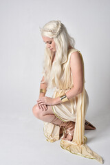 Full length portrait of beautiful blonde woman wearing a fantasy goddess toga costume with  magical...