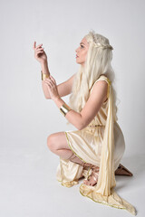 Full length portrait of beautiful blonde woman wearing a fantasy goddess toga costume with  magical...