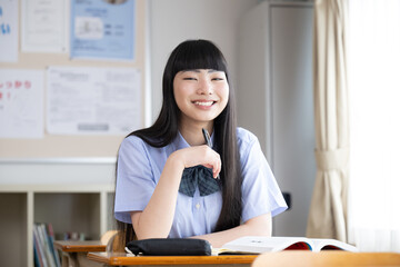 High school girls studying in a classroom, looking at the camera, short sleeves, with space for photocopying