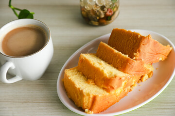 pieces of sponge cake or kue bolu served on a plate with a glass of coffee