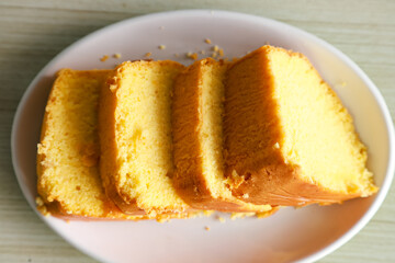 pieces of sponge cake or kue bolu served on a plate with a glass of coffee