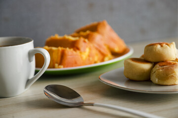 pieces of sponge cake or kue bolu served on a plate with a glass of coffee