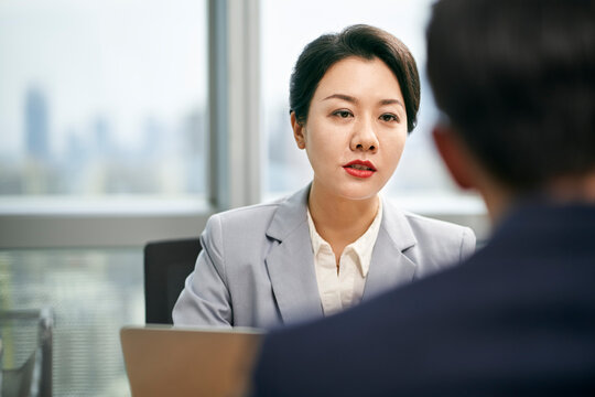 asian business woman talking to colleague in office