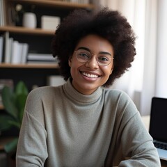 smiling african american woman at her desk in an office with glasses