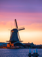 The picturesque Zaanse Schans of the Netherlands, with an iconic windmill against a dreamy sunset...