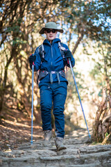 A young traveller trekking on forest trail , Nepal