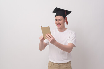 Young smiling man holding graduation hat, education and university concept.
