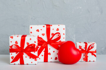 gift box with red bow and red heart on colored background. Perspective view. Flat lay