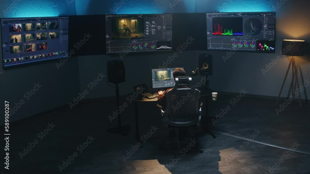 Poster the video editor works in studio on computer, uses color grading control panel, edits video, makes c