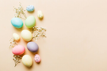 Naklejka na ściany i meble Happy Easter composition. Easter eggs on colored table with gypsophila. Natural dyed colorful eggs background top view with copy space