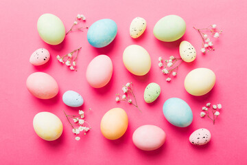 Happy Easter composition. Easter eggs on colored table with gypsophila. Natural dyed colorful eggs background top view with copy space