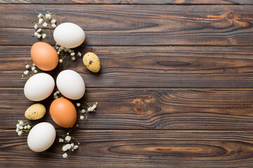 Happy Easter composition. Easter eggs on colored table with gypsophila. Natural dyed colorful eggs background top view with copy space