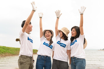 Fototapeta premium Volunteers from the Asian youth community using rubbish bags cleaning up nature par