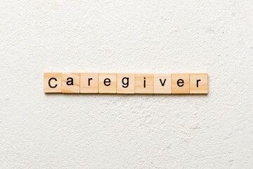 Caregiver word written on wood block. Caregiver text on table, concept