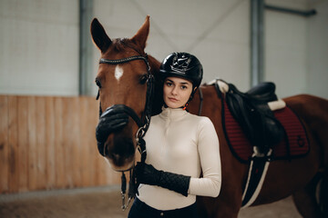 Fototapeta na wymiar Horse riding. A young woman with a horse.
