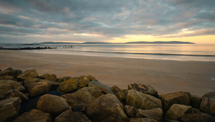 Dramatic cloudy sunrise landscape scenery of sandy Silverstrand beach in Galway, Ireland 
