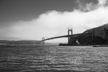 Aerial grayscale shot of the famous Golden Gate Bridge in San Francisco  covered by fog in summer