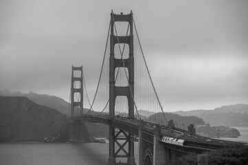 Aerial grayscale shot of the famous Golden Gate Bridge in San Francisco  covered by fog in summer