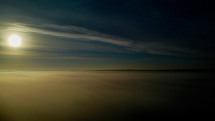 Fototapeta premium Long-exposure aerial view of a steam-covered seascape at sunset