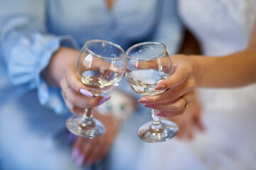 Two girls holding champagne glasses and cheers to each other
