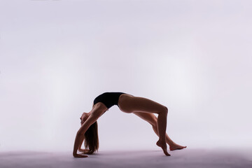 Young beautiful yoga female posing on a studio background