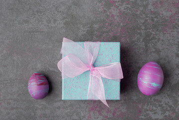 Gift boxes and painted Easter eggs on stone background. Easter gift concept