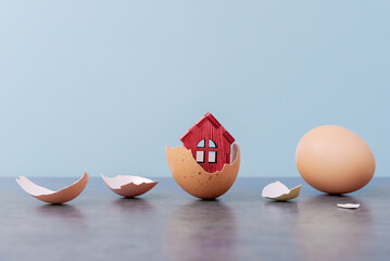 Tiny house in eggs shell over blue background with copy space. Conceptual Easter greeting card - 589109696