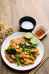 Thai food (Pad See Ew), Stir fried rice noodles soy sauce with pork, egg and kale on wooden background