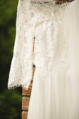 Vertical closeup shot of details on a lace white wedding dress