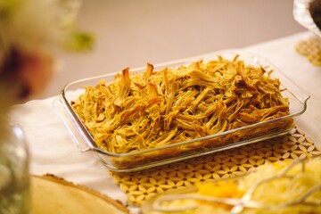 High angle closeup shot of shredded  chicken in a glass tray on a table
